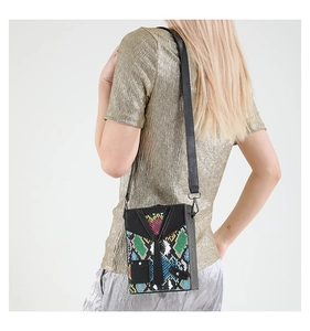Detail of crossbody bag in suit design with snake skin pattern and tie accent