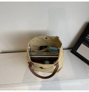 Top view of canvas tote bag interior with multiple compartments and leather handle