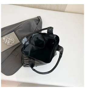 Interior view of black litchi pattern tote bag showing zip pocket and textile lining