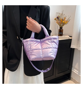 Detailed view of lavender quilted puffer bag with metallic finish and top handles