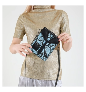 Detail of blue snakeskin crossbody bag with black suit collar design and metal hooks