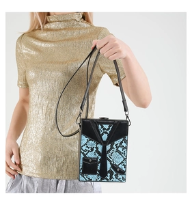 Detail of snake print hard shell box bag with suit-style design and leather strap