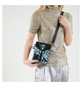 Detail of blue snakeskin box bag featuring creative black tie suit design on model