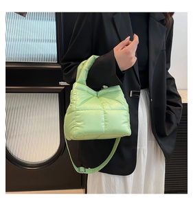 Detailed view of neon green quilted puffer tote bag with padded handle and crossbody strap