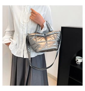 Close-up of shiny silver quilted padded bucket bag with metallic texture and strap