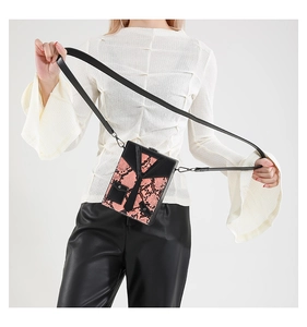 Detail of pink snake pattern crossbody bag with suit design worn by a female model
