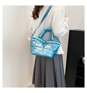 Detail of light blue puffer tote bag with metallic finish and quilted padded texture