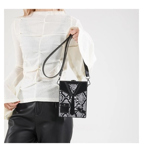 Detail of creative suit-style tuxedo box bag with snakeskin pattern and tie detail