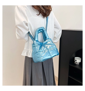 Detailed view of glossy blue quilted tote bag featuring metallic finish and padded texture
