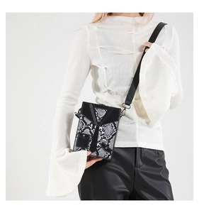 Detail of vintage punk style box bag with suit-tie design and snake pattern leather