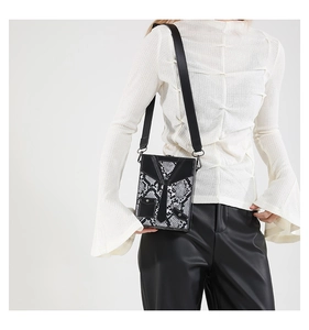 Detail shot of white and black snakeskin box bag with unique leather tie design