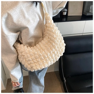 Detail of white bubble texture fabric on a stylish tote bag with soft crescent shape