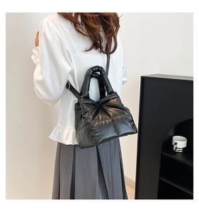 Detail view of the black quilted padded tote bag with glossy finish and crossbody strap