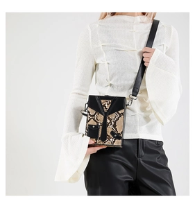 Detail of snake skin pattern hard shell box bag with creative tuxedo suit design elements