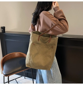 Detail view of large canvas tote bag with leather handles and olive green vintage wash