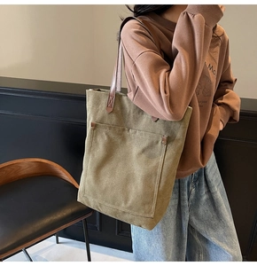 Bolso tote grande de lona verde oliva con asas de cuero marrón y remaches metálicos