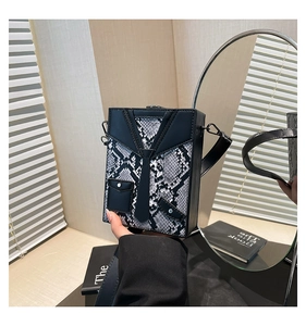 Detail of creative suit-style hardshell box bag with snakeskin texture and metal hooks