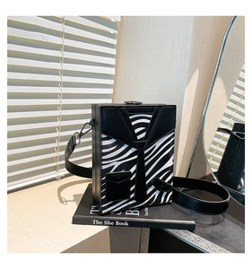 Close-up of zebra pattern hard shell box bag with suit detail and tie design