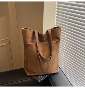 Macro detail of brown washed canvas tote bag with metal rivets and sturdy strap