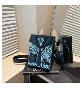 Detail of creative suit and tie design on snake pattern hardshell crossbody bag