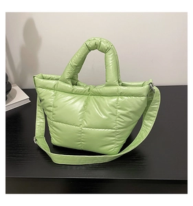 Detail of light green quilted down tote bag with padded handles and square patterns