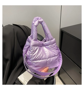 Detail of purple quilted puffer bag featuring glossy waterproof nylon and thick handle