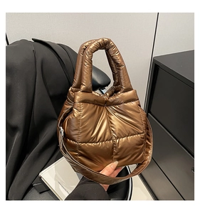 Detail view of the quilted padded bronze tote bag with high-gloss nylon texture and wide strap