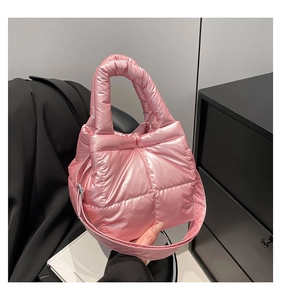 Detail of pink quilted puffer handbag with glossy finish and square padded texture