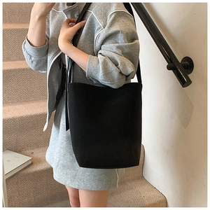 Minimalistische schwarze Eimer-Tasche aus mattem Leder mit langem Schultergurt