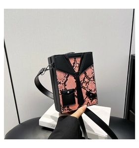 Detail of pink snake pattern crossbody box bag with creative tuxedo suit design elements