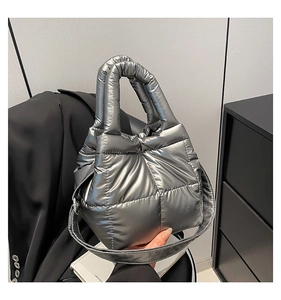 Detailed macro view of metallic silver quilted puffer bag with high-gloss finish and stitching