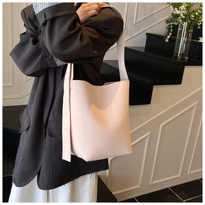 Detail der hellrosa Beuteltasche mit verstellbarem Gurt an der Schulter des Models