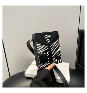Macro shot of zebra pattern shoulder box bag with tuxedo design and adjustable strap