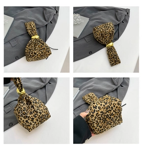 Detail showing leopard print wrist bag with a gold pebble ring and ruched fabric texture
