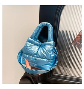 Close-up of a light blue quilted down tote bag with metallic glossy finish and thick handles