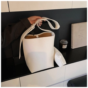 Details der minimalistischen cremefarbenen Beuteltasche mit breitem Gurt und Beutel
