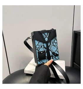 Detail of creative suit-style crossbody bag with blue python print and tie design