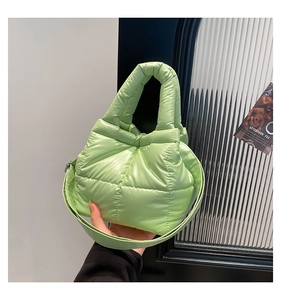 Detail of light green puffer tote bag showing quilted texture and crossbody strap