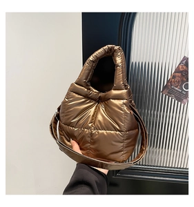 Detailed view of the metallic bronze down tote bag with quilted stitching and wide strap