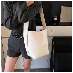 Detailansicht der weißen Bucket Bag mit Lychee-Struktur und breitem Schultergurt-Design