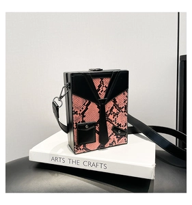 Detailed view of pink snakeskin crossbody bag with creative black suit collar design