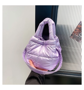 Detail of purple quilted down puffer tote bag with metallic finish and wide shoulder strap