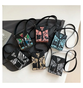Selection of hard shell box bags in snake skin and zebra prints with suit-style necktie design