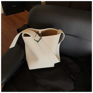 Detailansicht der cremeweißen Beuteltasche mit Kieselledertextur und silberner Schnalle