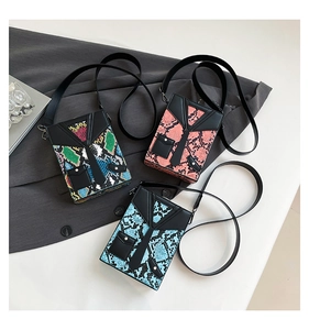 Detailed view of trendy faux snake skin crossbody box bags in three vibrant suit-inspired designs