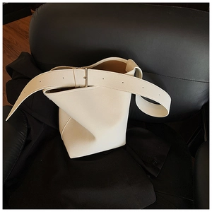 Detailaufnahme der cremeweißen Eimertasche aus genarbtem Leder mit Metallschnalle