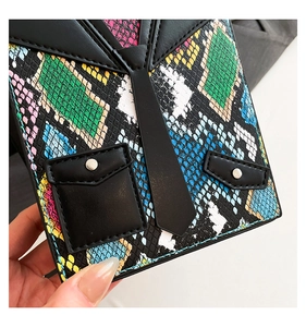 Macro detail of tuxedo-style bag with colorful python texture and mini tie decor