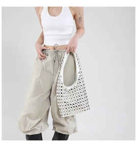 Detail der weißen Hobo-Tasche mit silbernen Nieten und Kunstleder-Oberfläche
