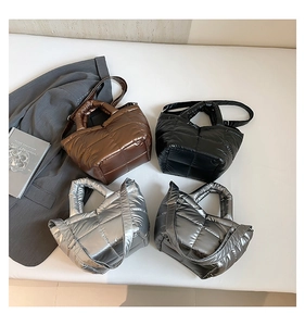 Detailed view of quilted puffer tote bags in four metallic colors with adjustable straps