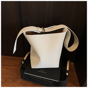 Detail der weißen minimalistischen Eimertasche mit Litschi-Leder und silberner Schnalle